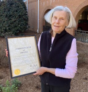 Leslie Bowie holding her framed certificate.